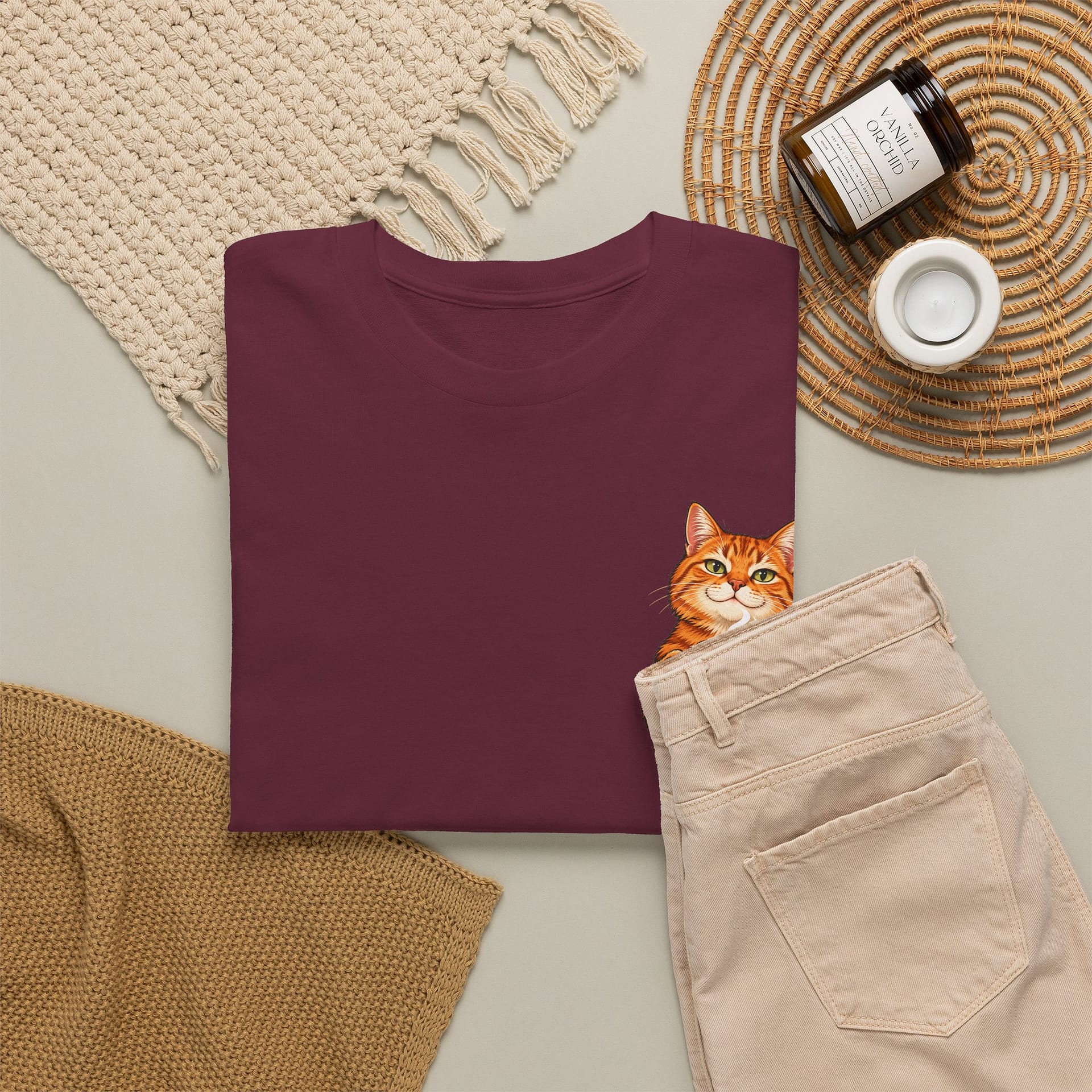 Close‑up of orange cat holding coffee mug graphic on T‑shirt