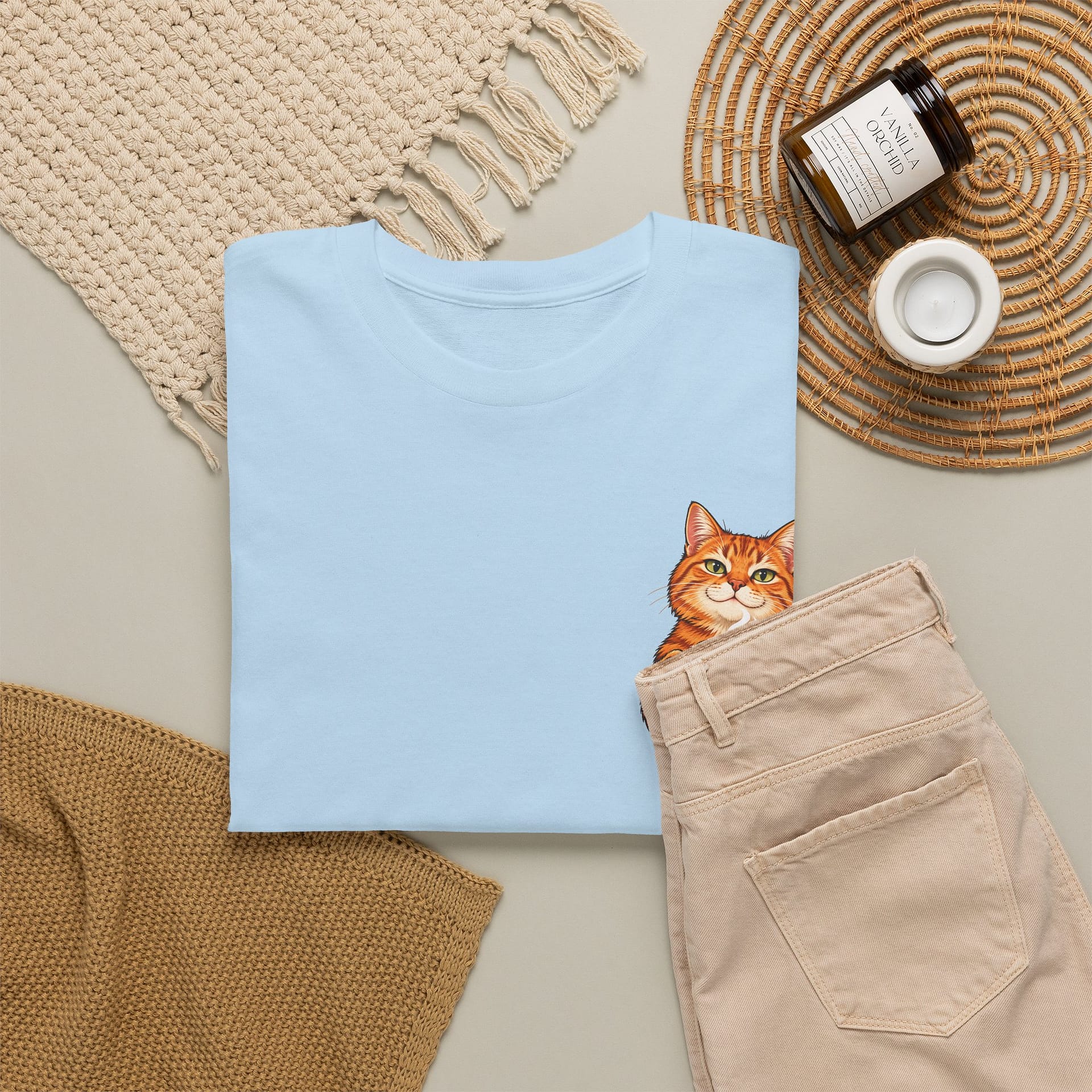 Close‑up of orange cat holding coffee mug graphic on T‑shirt